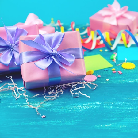 Festive bright blue background decoration for holiday colored confetti serpentine paper gifts. Top view flat lay copy space Christmas candy snowflakes toys squareの写真素材