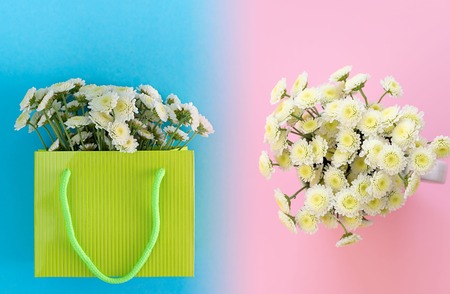 A beautiful bouquet of white chrysanthemum flowers in a bright paper bag packaging. The view from the top of the gradient background blue pinkの写真素材