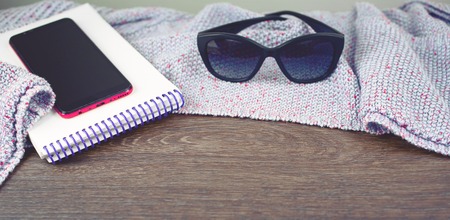 Banner Empty space on your desktop mobile phone gadget Notepad sunglasses. Old natural wooden shabby background knitted blanket plaid purple color toningの写真素材