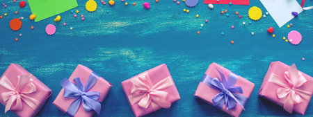 Banner Festive bright blue background decoration for holiday colored confetti serpentine paper gifts. Top view flat lay copy space toningの写真素材