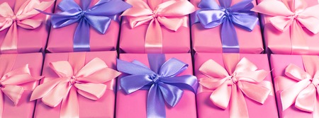 Banner Rows of boxes with gifts decoration ribbon satin bow pink. A top view of Flat lay toningの写真素材