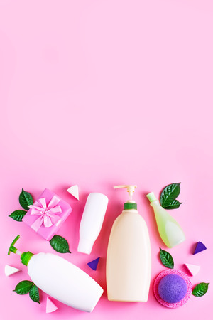 Cosmetic packaging plastic bottle shampoo cream shower gel milk green leaves sponge box gift bow. Natural organic product skin and hair care shopping. Top view pink flat lay background vtrtical.の写真素材