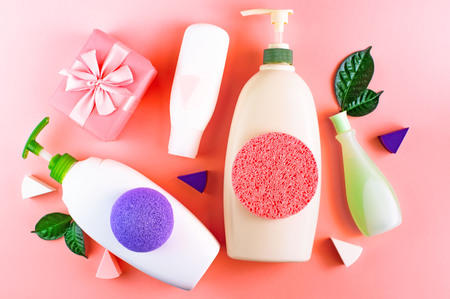 Cosmetic packaging plastic bottle shampoo cream shower gel milk green leaves sponge box gift bow. Natural organic product skin and hair care shopping. Top view pink flat lay background.の写真素材
