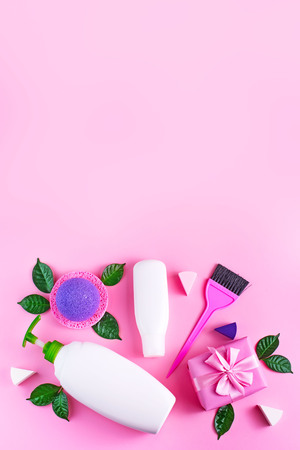Cosmetic packaging plastic bottle shampoo cream shower gel milk green leaves sponge box gift bow. Natural organic product skin and hair care shopping. Top view pink flat lay background vertical.の写真素材