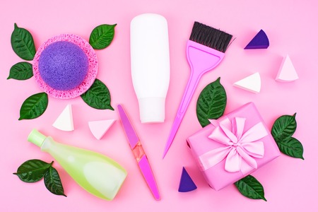 Cosmetic packaging plastic bottle shampoo cream shower gel milk green leaves sponge box gift bow. Natural organic product skin and hair care shopping. Top view pink flat lay background. Selective focusの写真素材