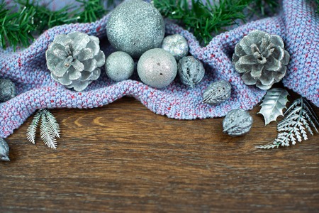 Christmas composition shiny balls nuts cones branches cedar leaves silver on wooden darkの写真素材