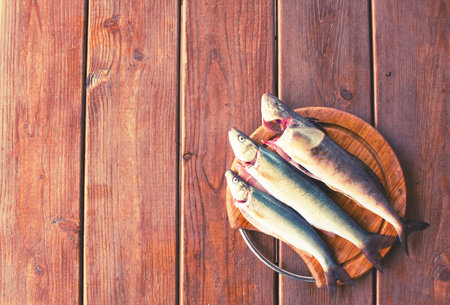 Fresh sea fish catch lies on a cutting Board on a wooden table Top view copy space