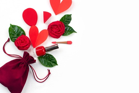 Velvet bag with gifts red roses green leaves cosmetics. The concept of Valentine's day. A top view of Flat layの写真素材