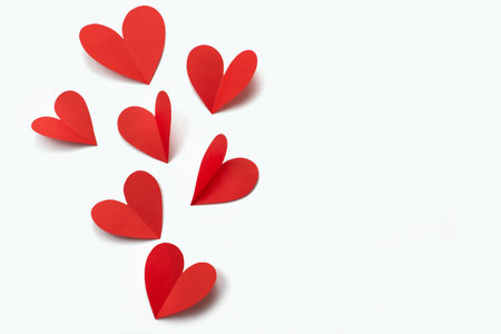 Red paper hearts on white background. The concept of Valentine's day
