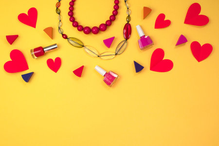 Set of cosmetics women's accessories jewelry. Red heart on yellow background. The concept of Valentine's dayの写真素材