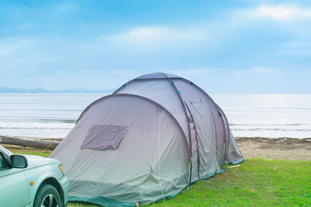 Seascape summer travel machine tent rubber boat Coastline horizon sky with cloudsの写真素材