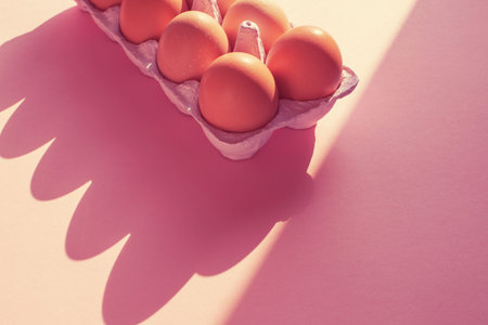 chicken eggs on toned coral background top view of Flat lay
