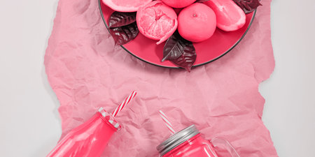 Banner Red plate with oranges and tangerines bottle with juice toned living coral Top view copy spaceの写真素材