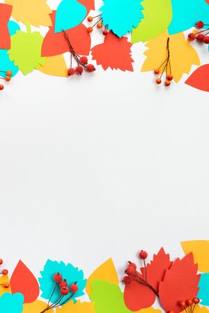 Autumn composition frame. Paper colored leaves branches berries on white background. The concept of autumn. Flat lay top viewの写真素材