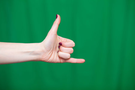 Hand female fingers closeup on a green background