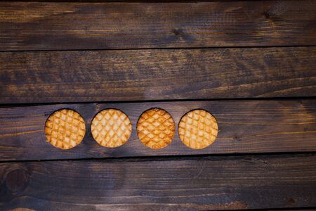 Four round pastry on dark wooden backgroundの写真素材