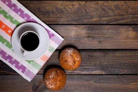 Coffee in white cup with two cupcakes on the wooden backgroundの写真素材