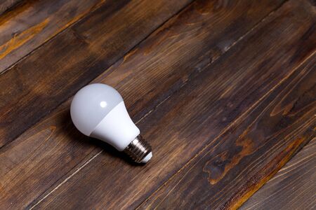 White LED light bulb on wooden background.の写真素材