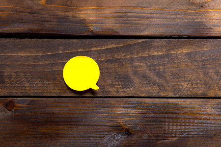 Yellow sticker for notes and reminders on wooden background.の写真素材