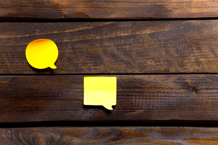 Two yellow stickers for notes and reminders on wooden background.の写真素材