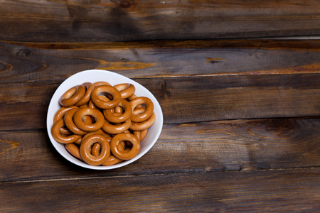 Russian bagels, bread in a white plate on wooden background.の写真素材