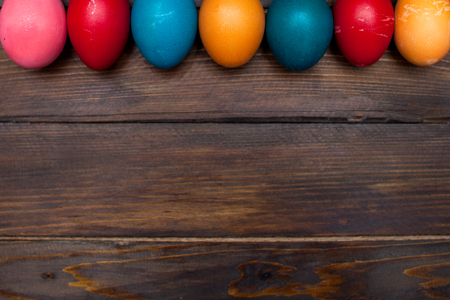 Closed, colored in different bright colors chicken eggs for the holiday Easter on natural wooden background.の写真素材