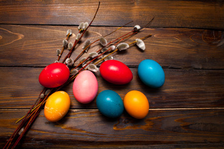 Beautiful branch of willow and easter eggs wood background.
