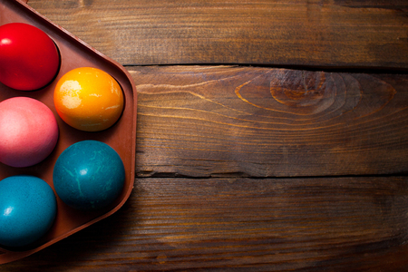 Multicolored chicken, painted eggs for the Easter holiday in box on wooden weathering background.の写真素材