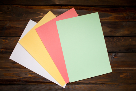 Colored A4 sheets on wooden background. Top view with copy space.の写真素材