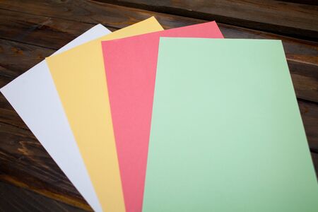 Colored A4 sheets on wooden background. Top view with copy space.の写真素材