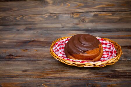 Delicious, fresh pretzel in chocolate in a wicker basket on a wooden background.の写真素材
