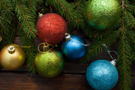New Year's green balls with fir branches on a wooden background. Top view.の写真素材