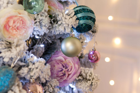 New Year artificial Christmas tree decorated with colorful bright balls on a blurry light...
