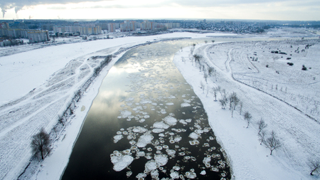 Ice swims in the river. Winter landscape photographed from above near the city. Top view. Nature and abstract background.の写真素材
