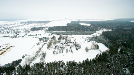 Winter forest and the road. View from above. The photo was taken with a drone. Pine and fir forest in the snow.の写真素材