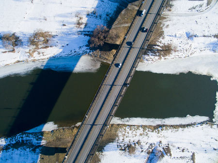 Photo from above with roads, building, lots, bridges, river on a winter day. Aerial city view with cars.の写真素材
