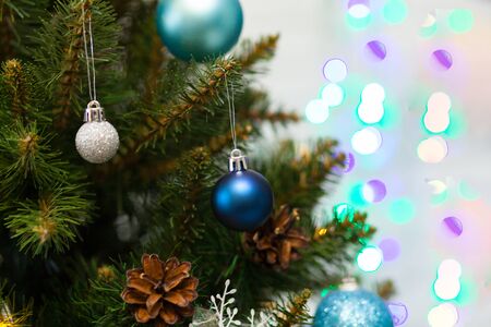 Beautiful green Christmas tree decorated with balls and garlands. Close-up photo. Sparkling backgroundの写真素材