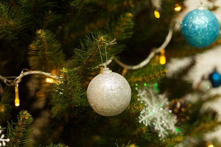 Beautiful green Christmas tree decorated with balls and garlands. Close-up photo