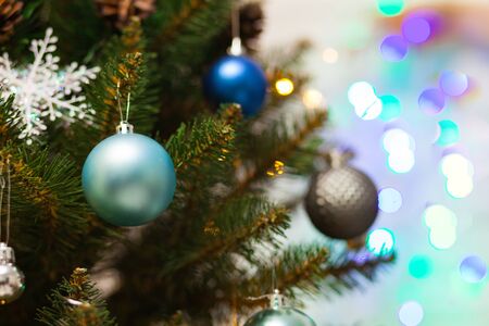Beautiful green Christmas tree decorated with blue balls and garlands. Close-up photo. Sparkling backgroundの写真素材