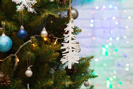 Beautiful green Christmas tree decorated with balls, big white tree and garlands. Close-up photo. Sparkling backgroundの写真素材