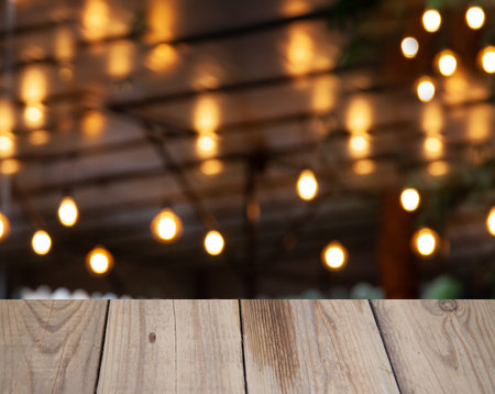 blurred cafe background with light bulbs with wooden table