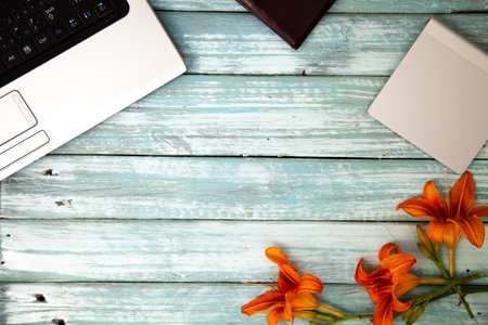lying on the table laptop notebook touchpad and orange flower