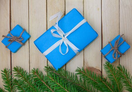 Christmas toys with fir branches on a wooden table, gift box, empty place, New Year concept. View from above.の写真素材