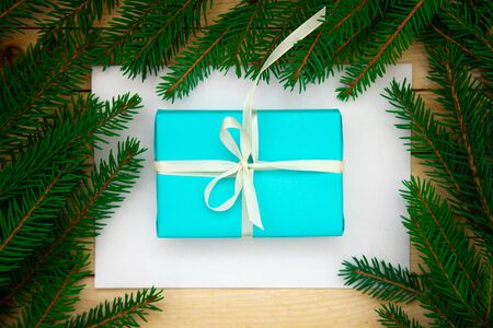 Christmas toys with fir branches on a wooden table, gift box, empty place, New Year concept. View from above.の写真素材