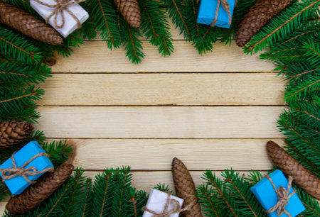 Christmas toys with fir branches on a wooden table, gift box, empty place, New Year concept. View...