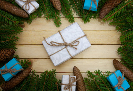 Christmas toys with fir branches on a wooden table, gift box, empty place, New Year concept. View...