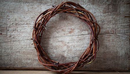 A rustic wreath made of twigs and twigs on a simple wooden background, and evergreen branches. A...