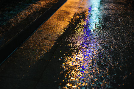 Colored light on wet asphalt in night city background
