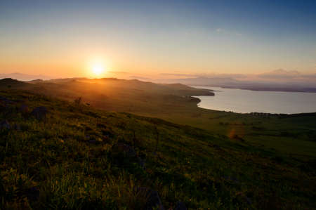 Sunset in the hills and the sea backgroundの写真素材