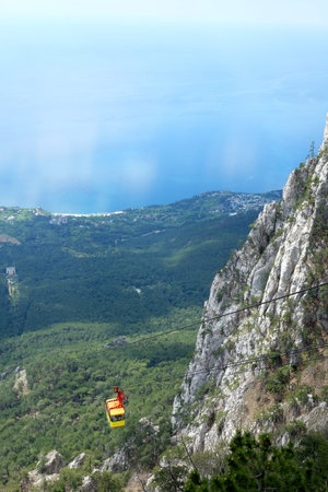 Yellow cable car in mountains above the valley top view from cableway station